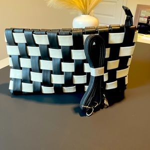 Black and.white checkered design hand clutch with strap.
